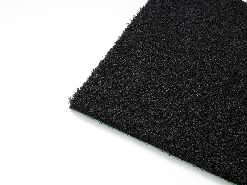 Рулон черной амортизирующей прокладки укладывается на базовый слой спортивного поля.